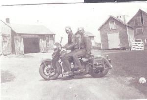 Dad (front) and Uncle Edward. Tool shed on left, grain house on right, milk house in middle.